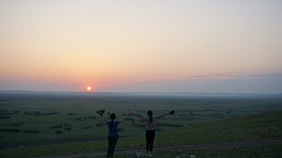 草原日落时的两人身影