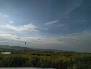 广阔原野上的蓝天绿树