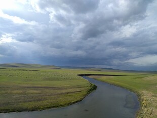 草原河流与阴沉天空景观