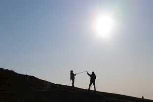 阳光下两人的山顶剪影