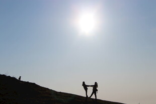 阳光下的山顶情侣剪影