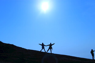 阳光下的山顶欢乐身影