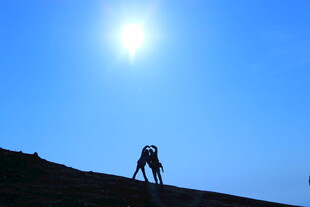 登山者逆光攀登壮丽山景
