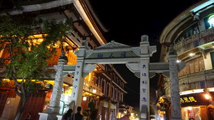 夜晚繁华街道的中式牌坊