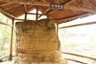 古朴石塔置于木质亭下