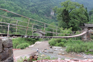 山间吊桥横跨潺潺溪流
