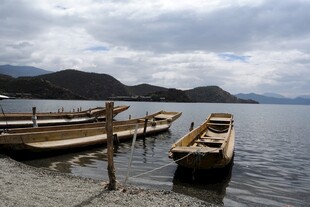 湖畔木船静泊于山水间