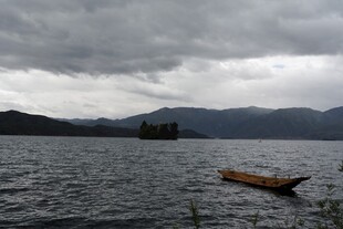 湖面上的孤舟与阴沉天空