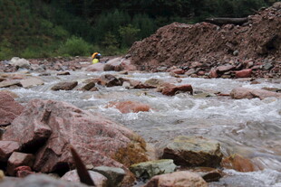 湍急溪流中的岩石与探险者