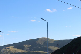蓝天山丘间的路灯景观