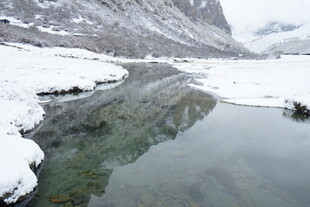 雪覆山川下的清澈溪流