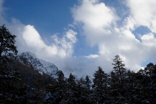 雪覆山林间的蓝天白云