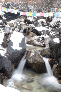 雪山溪流旁的经幡景观