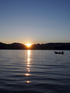 夕阳下湖面小船静谧景象