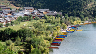 湖畔多彩船只与山村景致