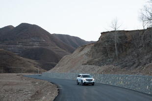 公路上行驶的白色轿车
