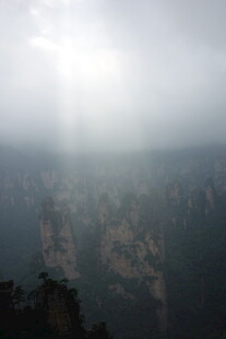 阳光穿透雾霭下的山峦