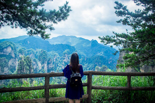 女子赏景于山间木栏旁