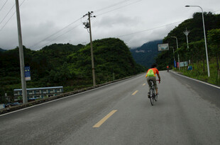 公路骑行者穿行青山间