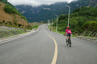 公路骑行者穿梭于山水间