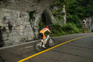 公路骑行者穿行山间隧道