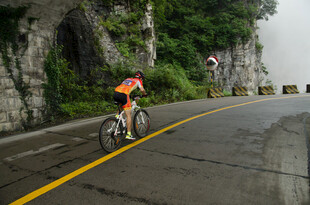 公路骑行者穿行山间隧道