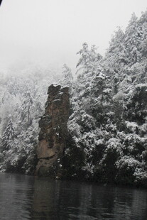 雪覆山林间的河畔岩石