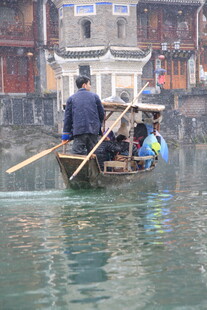 水乡船夫撑船游于河道
