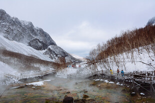 雪山下的溪流与徒步者