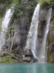 山间飞瀑下的碧绿湖水