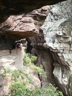 山间岩石下的骑行场景