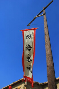 中式屋檐上的四海客栈旗