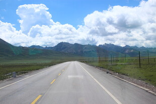 草原公路伸向蓝天白云