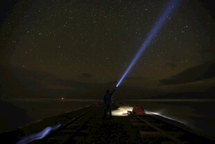 夜海船顶探照灯光束景象