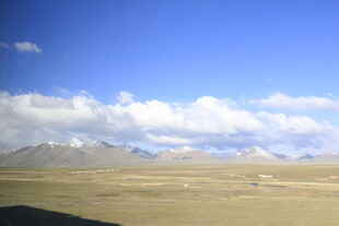辽阔草原上的蓝天白云雪山