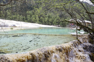 山间清澈瀑布下的碧绿湖水
