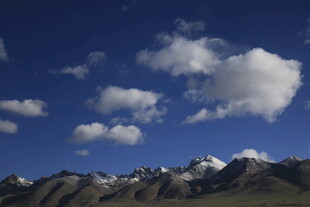 蓝天白云下的壮丽雪山