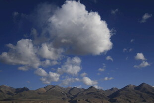 蓝天群山间的蓬松云朵