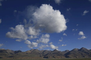 蓝天群山间的蓬松云朵