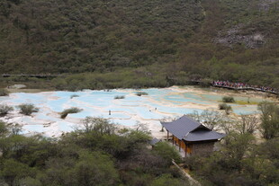 山间彩池旁的古朴小屋