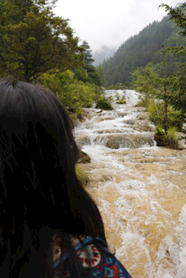女子赏山间湍急溪流