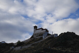 山巅古建映于蓝天白云间