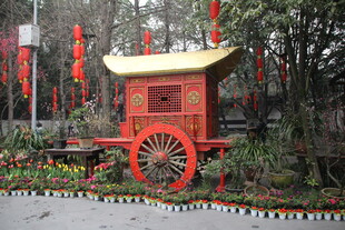 古典红色花轿静立园林中