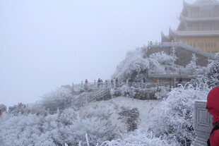 雪覆古建筑前的赏景之人