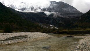 山间溪流与远处雪山美景