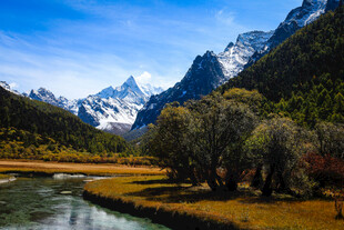 山间溪流旁的壮丽雪山景色