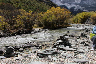 徒步者穿行于山间溪流旁