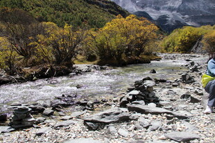 徒步者穿行于山间溪流旁