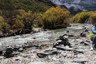 徒步者穿行于山间溪流旁