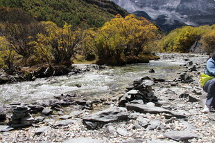 徒步者穿行于山间溪流旁